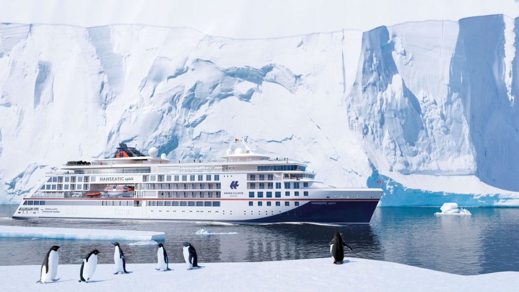 Hanseatic Spirit vor Eisbergen und hinter Pinguinen